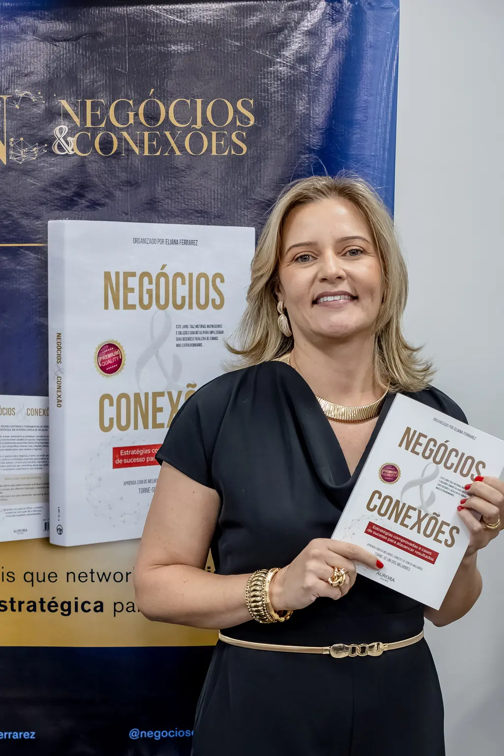 Eliana Ferrarez segurando o livro Negócios & Conexões no lançamento da coletânea